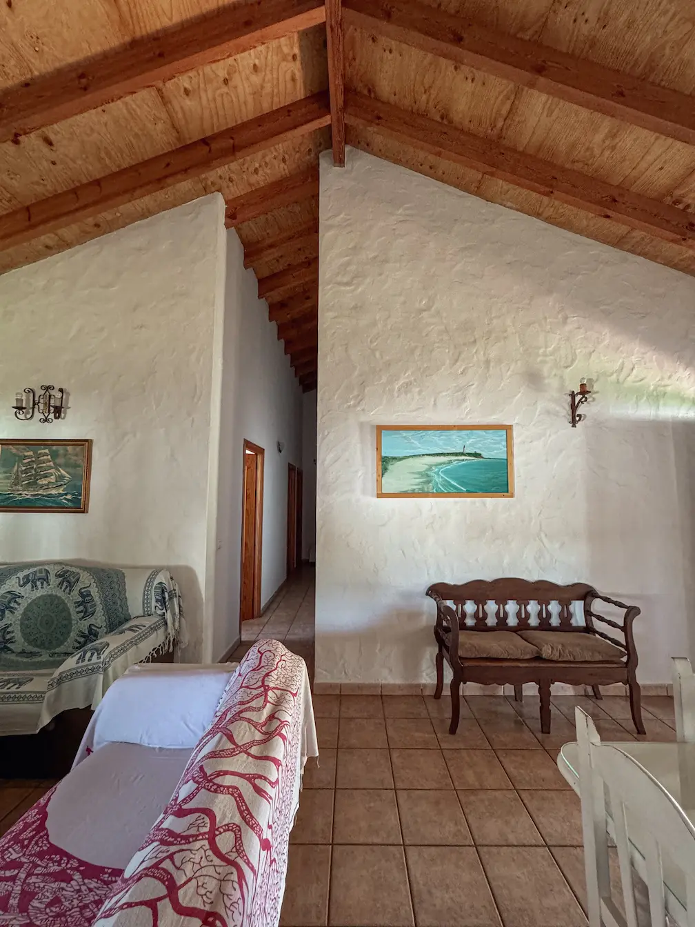 Vista al largo pasillo del interior de la casa. Altos techos con vigas de madera.