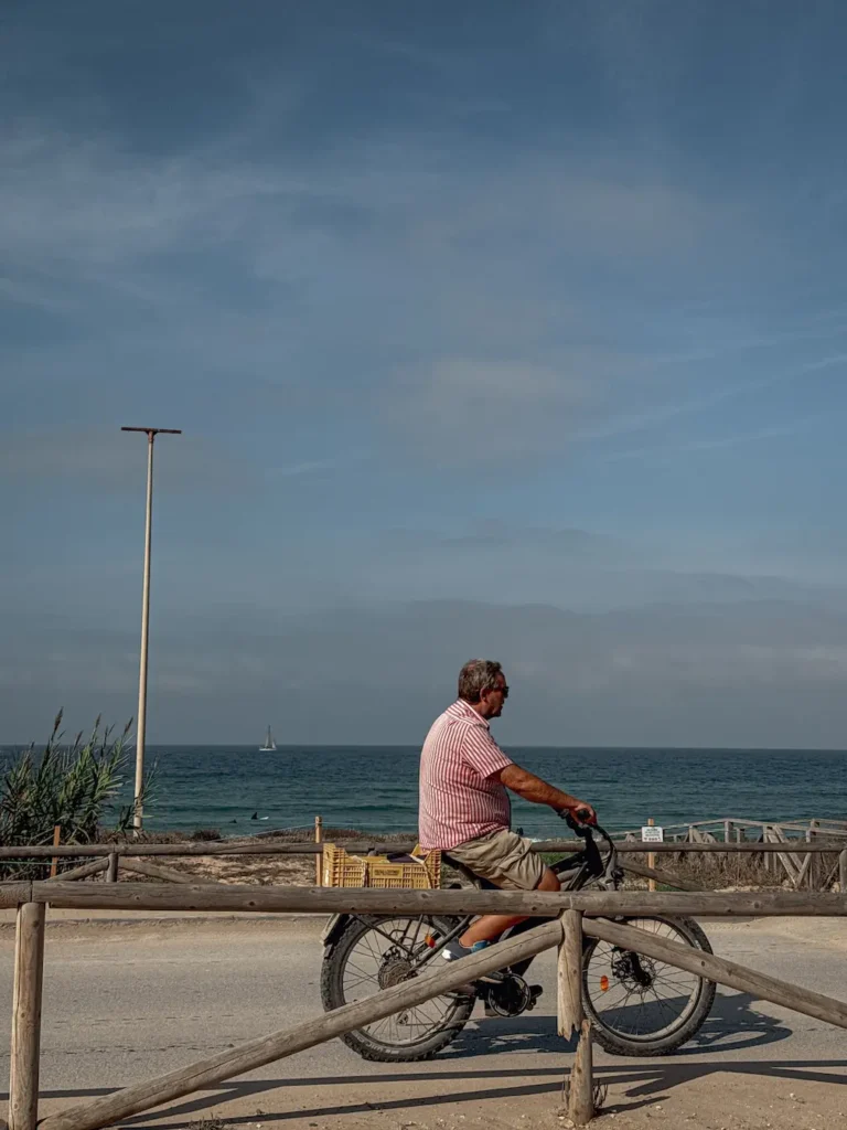Persona en bici paseando al lado de la playa.